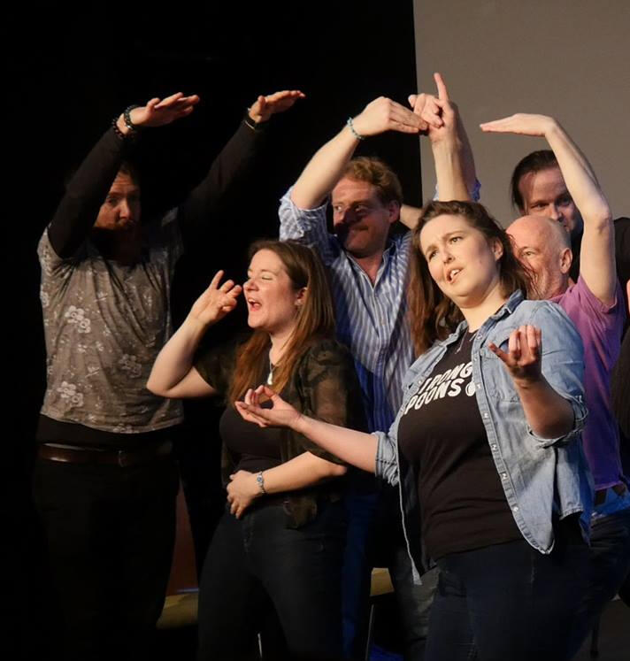 Erin on stage with an improv ensemble at The Waterside, Aylesbury. They are pulling a funny face and impersonating Donald Trump